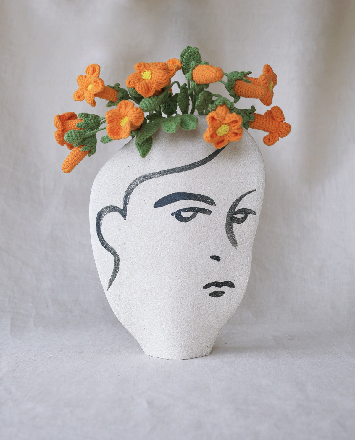 Hand-painted face vase by INI CERAMIQUE with illustrative patterns and a textured finish