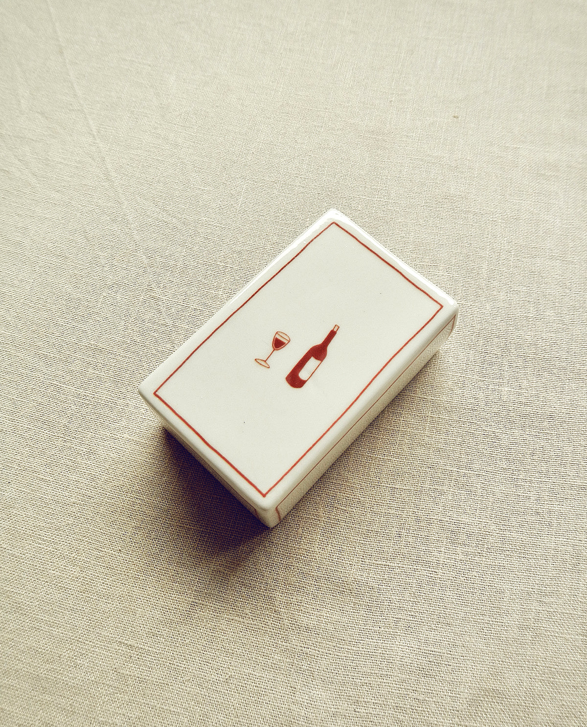 Hand-illustrated ceramic matchbox with wine bottle and glass illustration