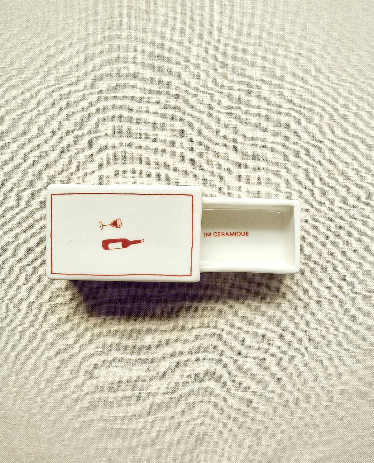 Hand-illustrated ceramic matchbox with wine bottle and glass illustration